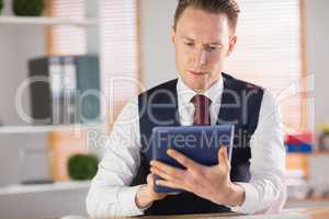 Focused businessman using his tablet pc