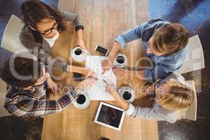 Friends drinking coffee and pointing on paper