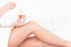 Woman holding hot wax in bowl at spa center