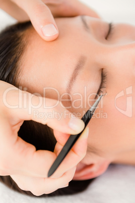 Woman placing fake eyelash on a patient