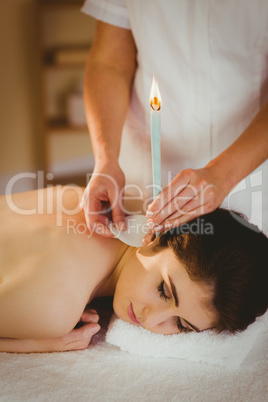 Young woman getting ear candling treatment