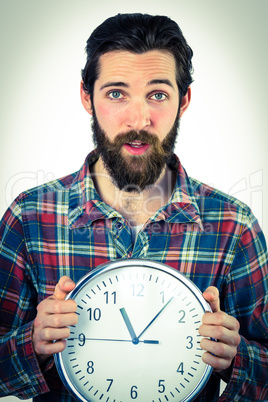 Handsome hipster showing a clock