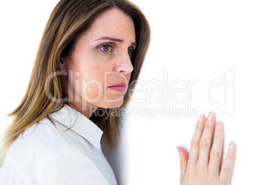 Depressed businesswoman leaning against a white wall