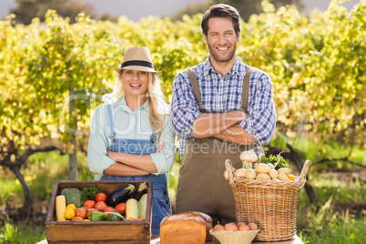 Happy farmer couple with arms crossed