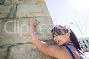 Athletic woman leaning against wall
