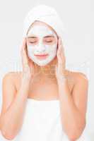 Attractive woman having white cream on her face at spa center