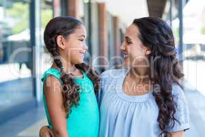 A mother and her daughter smiling at each other