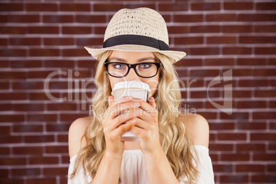 Gorgeous blonde hipster drinking out of take-away cup