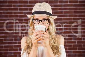 Gorgeous blonde hipster drinking out of take-away cup