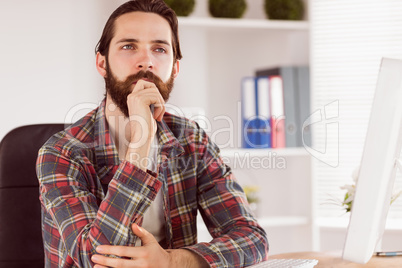 Hipster businessman sitting at his desk