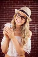 Gorgeous smiling blonde hipster with take-away cup