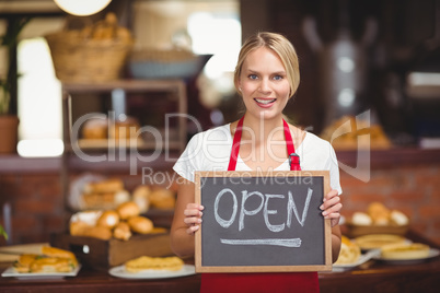 Pretty waitress with a chalkboard open sign