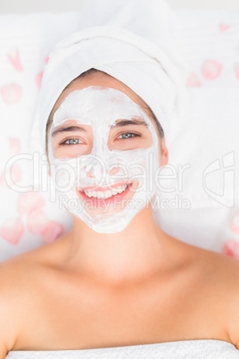 Attractive woman having white cream on her face at spa center