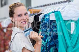 Smiling woman showing credit card to camera