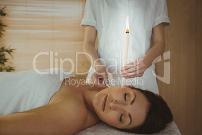 Young woman getting an ear candling treatment