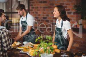 Pretty waitress talking with a customer