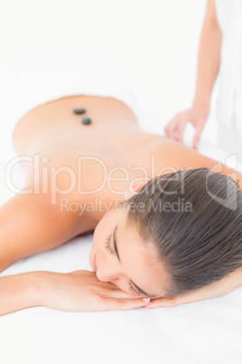 Beautiful brunette enjoying a hot stone massage