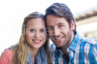 Cute couple sitting at a cafe smiling at camera