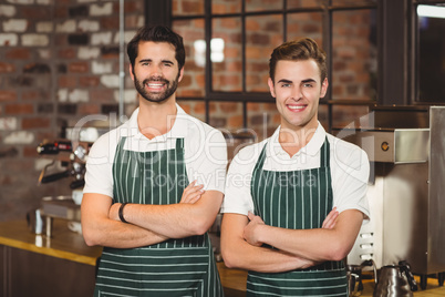 Two smiling baristas looking at the camera