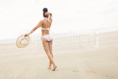 Fit woman in bikini walking to sea