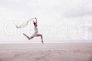 Stylish woman leaping with scarf