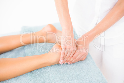 Woman receiving leg massage at spa center