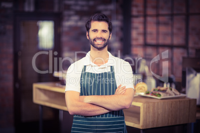 Smiling barista with arms crossed