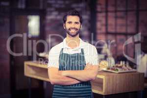 Smiling barista with arms crossed