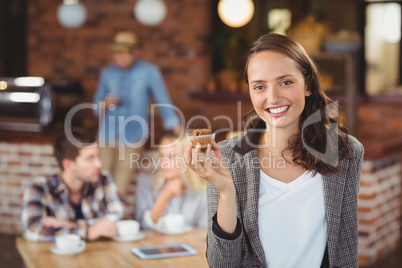 Smiling young woman holding muffin