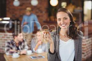 Smiling young woman holding muffin