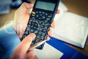 Businessman hands typing on calculator