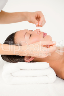 Hands threading beautiful womans face