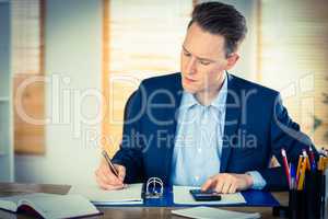 Concentrated businessman writing down