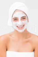 Smiling woman having white cream on her face