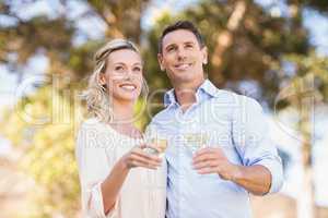 Smiling standing couple enjoying the view and holding wineglass