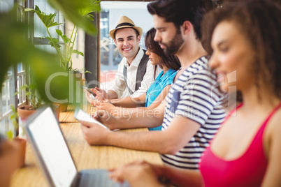 Happy friends using electronic devices