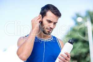 An handsome athlete holding a bottle