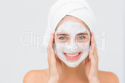 Attractive woman having white cream on her face at spa center