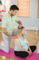 Pregnant woman getting massage for neck and shoulders