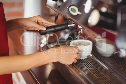 A smiling barista preparing coffee