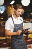 Handsome waiter using a tablet