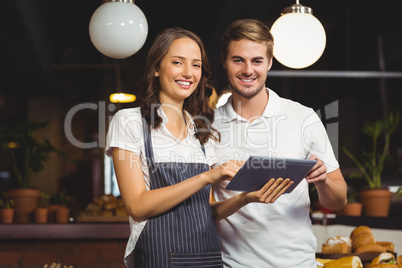 Smiling co-workers holding a tablet