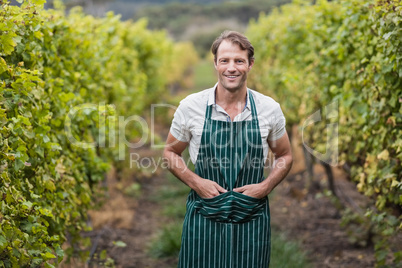 Happy vintner with hands in pockets