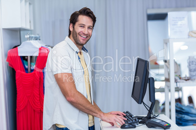 Smiling cashier typing