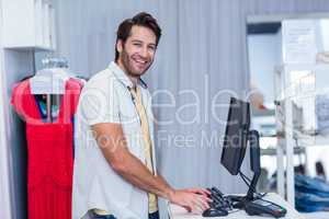 Smiling cashier typing