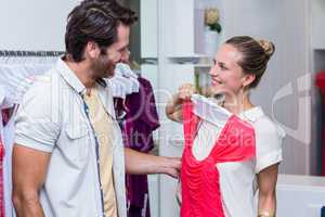 Smiling woman showing red dress to boyfriend