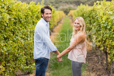 Young happy couple holding hands and looking at camera