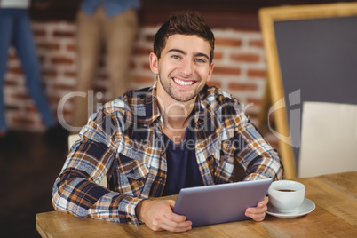 Smiling hipster using tablet computer