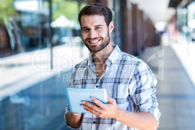 Hipster man using tablet computer in the city