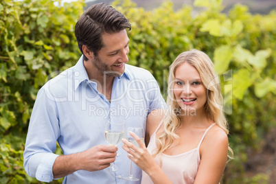 Young happy couple smiling at camera and toasting